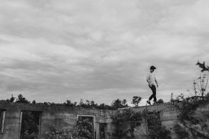 boy-walks-along-edge-of-abandoned-buildling