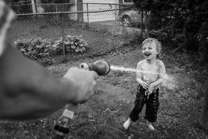 little-boy-sprayed-by-hose