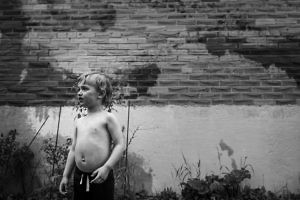 boy-in-backyard-with-brick-wall