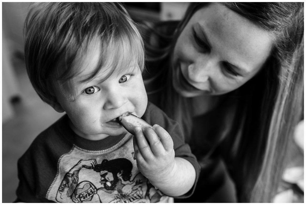 little-boy-chomps-on-cucumber-while-making-juice-with-his-mother