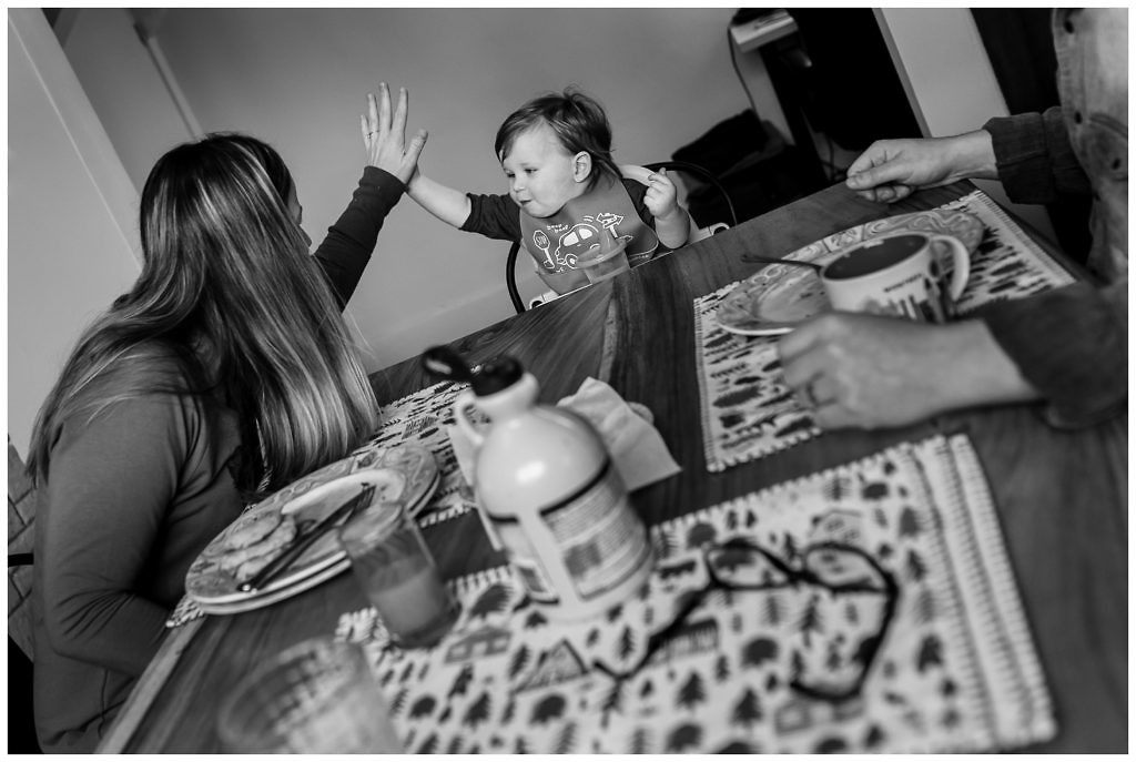 little-boy-high-fives-his-mom-at-the-kitchen-table-for-finishing-all-his-breakfast