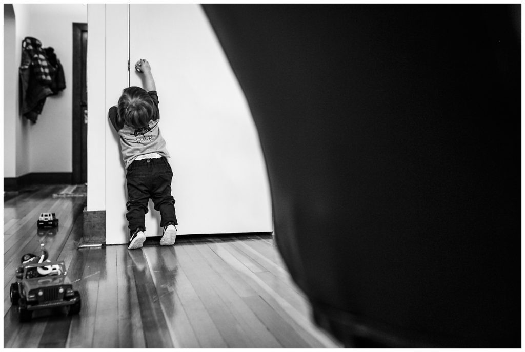 little-boy-attempts-to-open-basement-door-his-own-on-his-tippy-toes-in-his-revesltoke-home