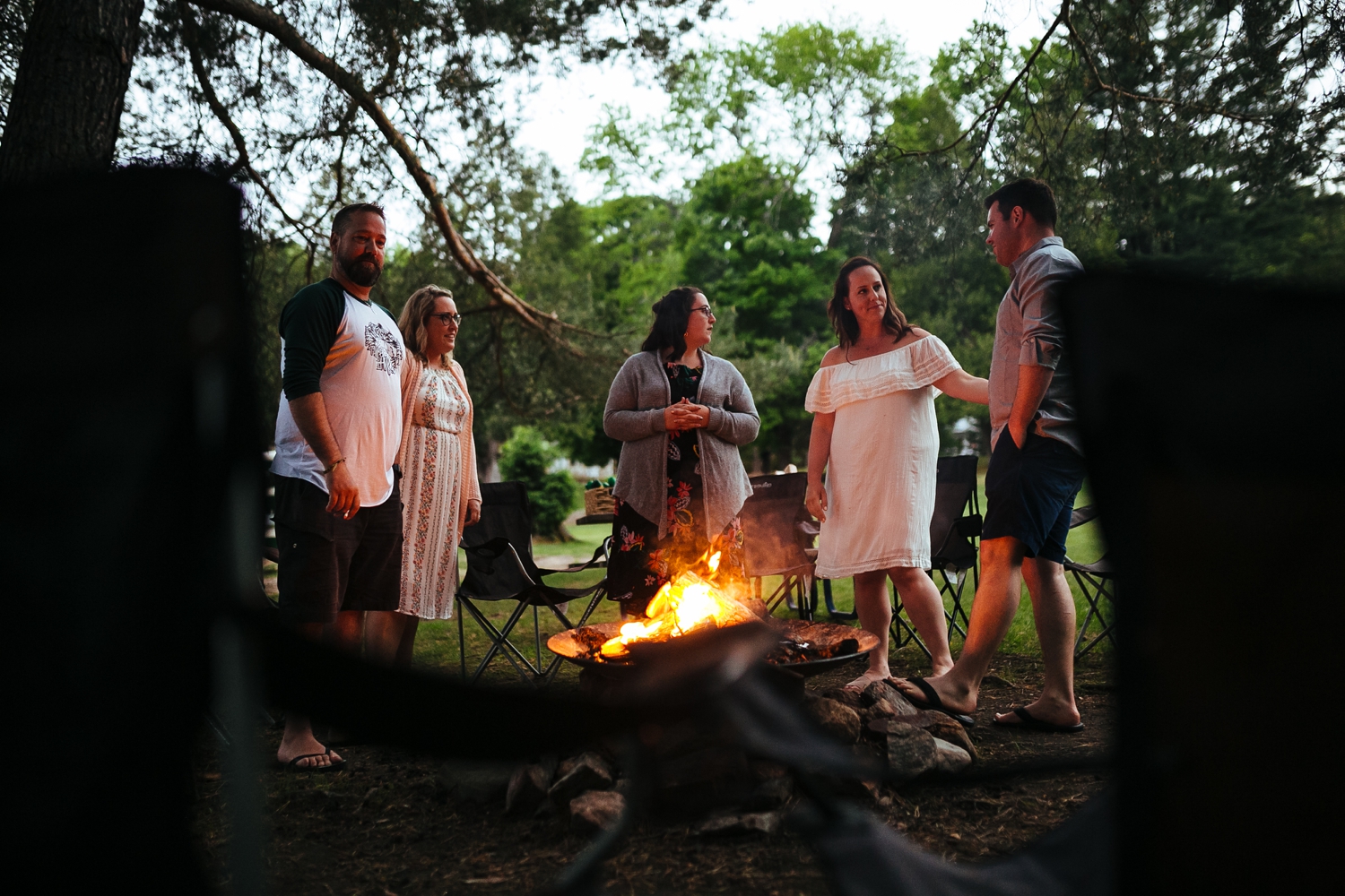 bride-and-groom-embrace-in-front-of-bonfire-on-warm-summer-night-on-shuswap-lake