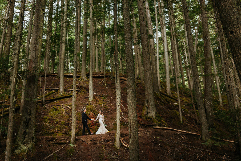 newly-married-couple-walk-up-a-forest-trail-at-begbie-falls-recreation-site-in-revelstoke-bc