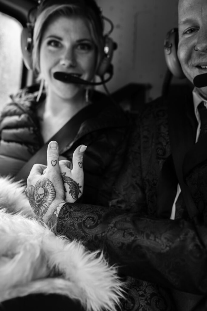 a-couple-show-off-their-matching-finger-heart-tattoos-while-on-a-helicopter-ride-to-their-revelstoke-elopement